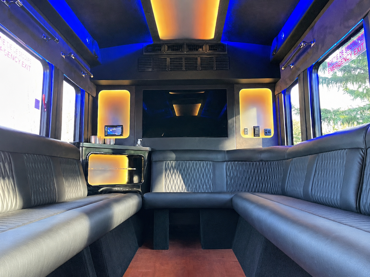 The inside of a bus with blue lights on the ceiling