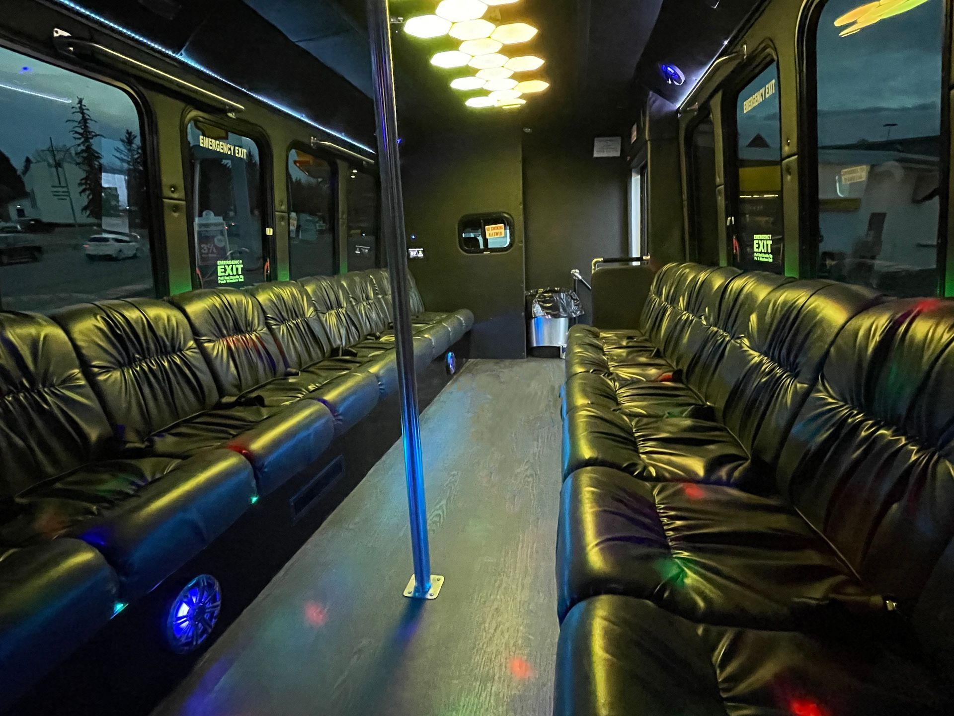 the inside of the Diamond Coach party bus with standing pole and plush seating