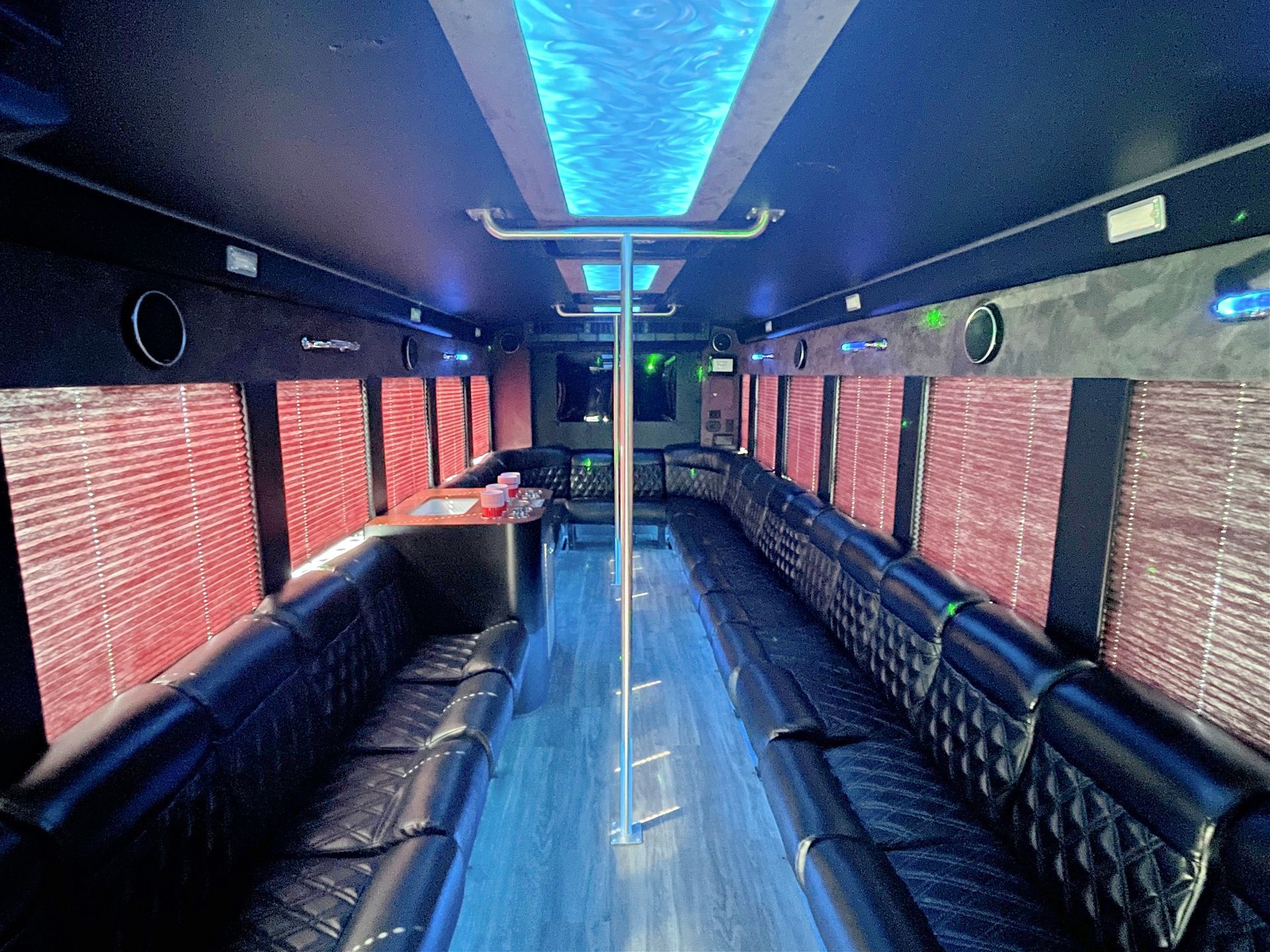 The inside of a limousine with purple lights on the ceiling.