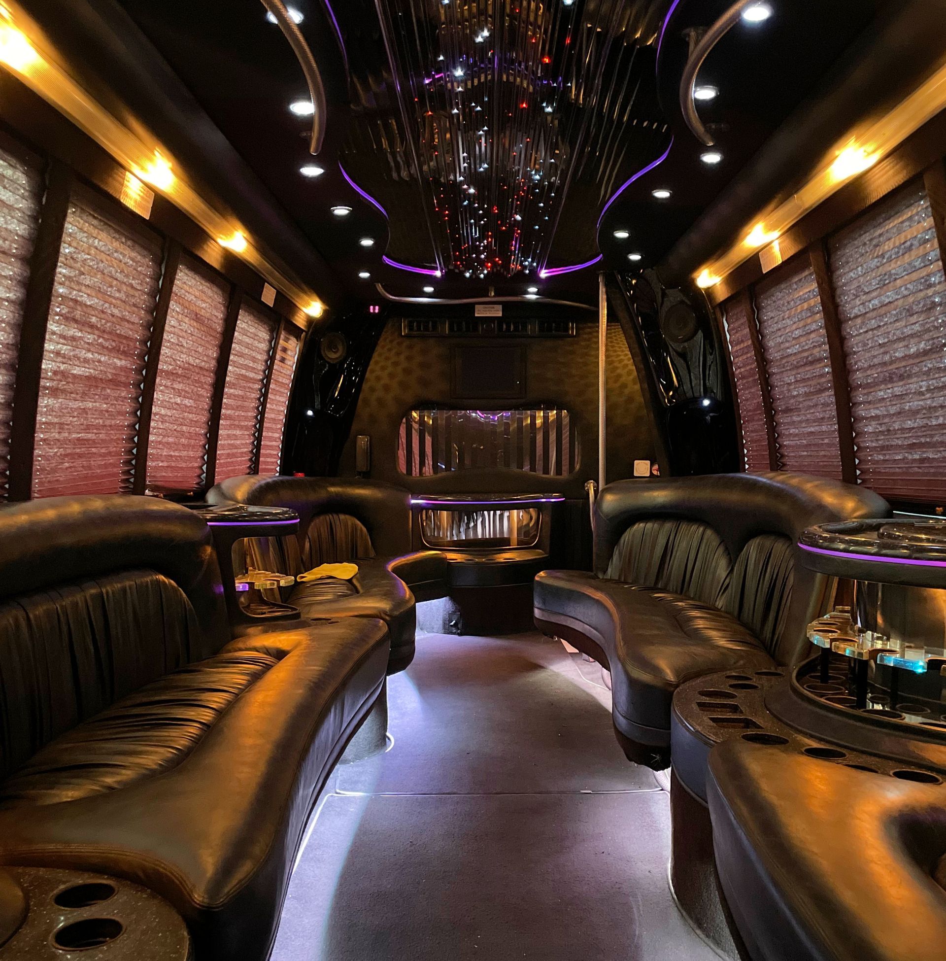 the inside of the Krystal Coach 24 passenger limousine with purple lights on the ceiling