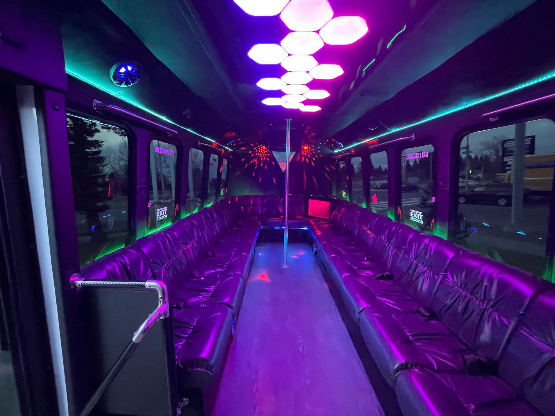 a limo to go party bus with purple seats and a sign that says exit