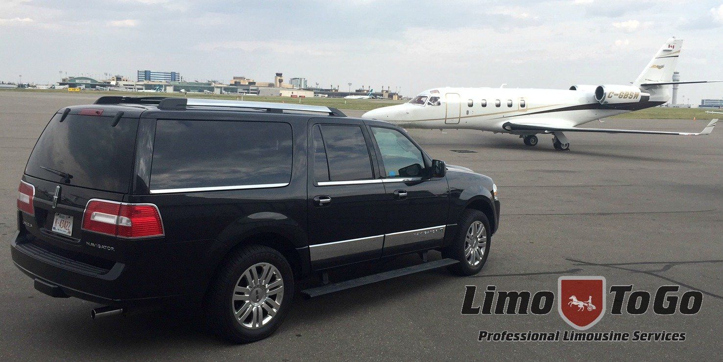 black Lincoln Navigator SUV parked in front of private Lear jet on tarmac of airport