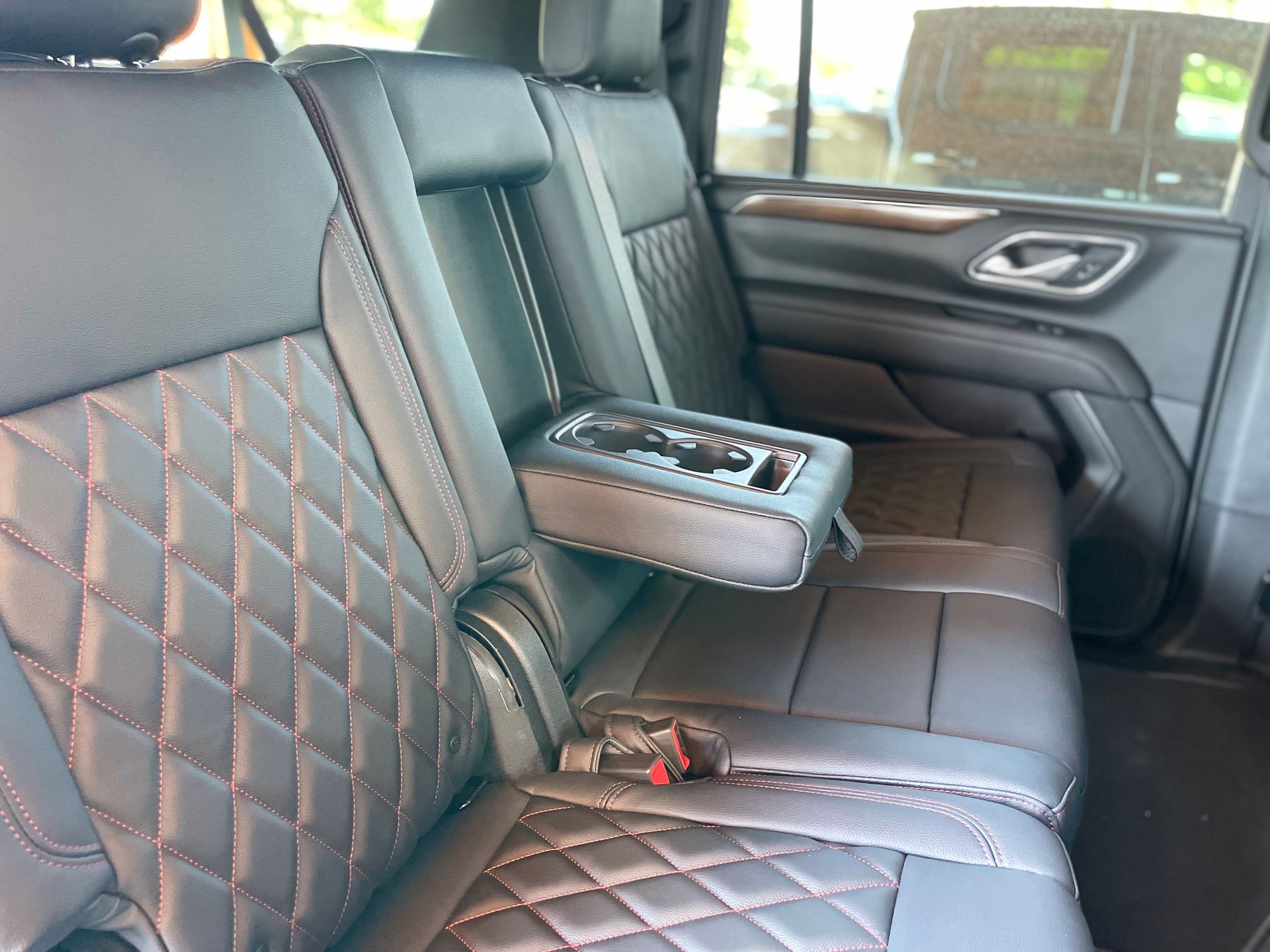 the second row seat of luxury Yukon SUV with cup holder on the arm rest