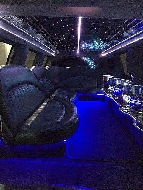 the inside of a limousine with blue lights on the ceiling