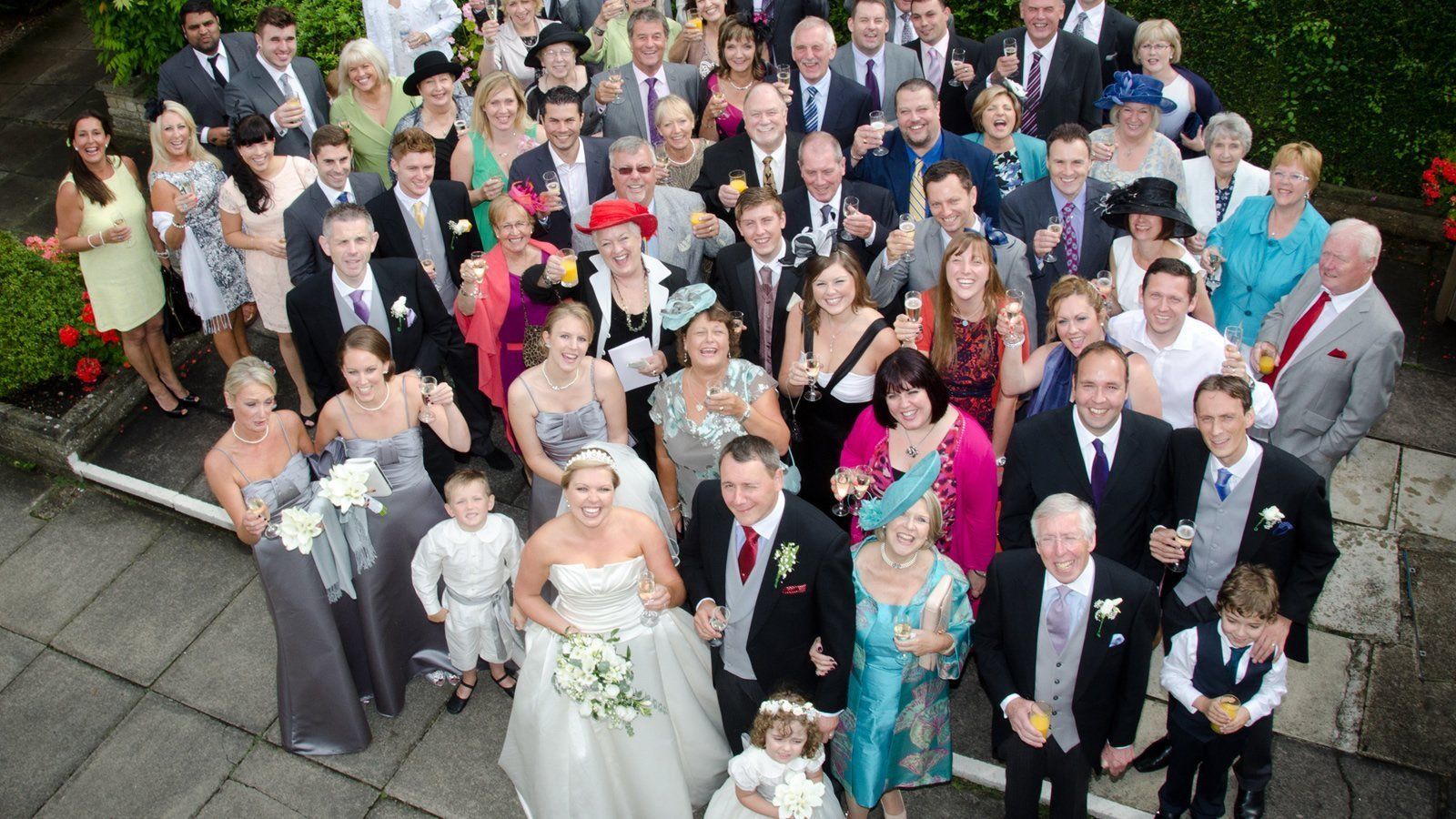 wedding guests with bride and groom smiling for photo