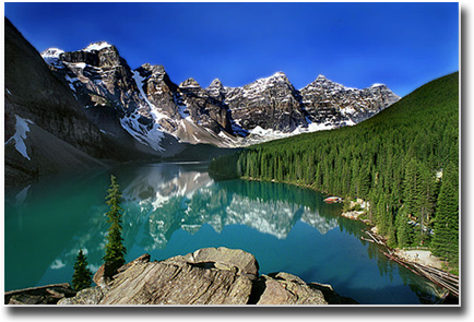 a lake with mountains in the background and trees on the shore