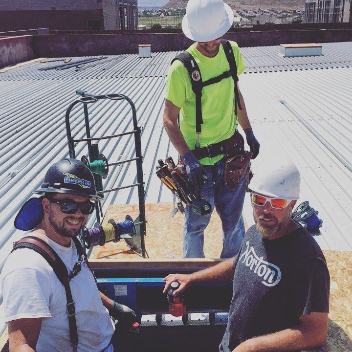 A man wearing a norton shirt is standing next to two other men