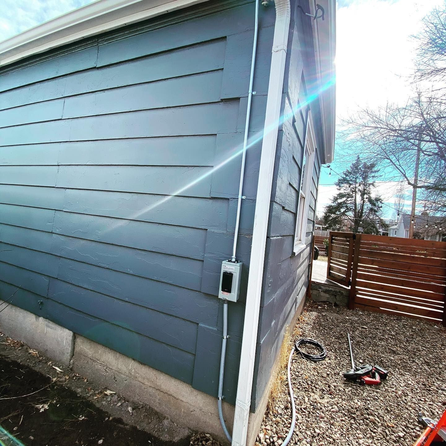 A house with a lot of wires on the side of it.