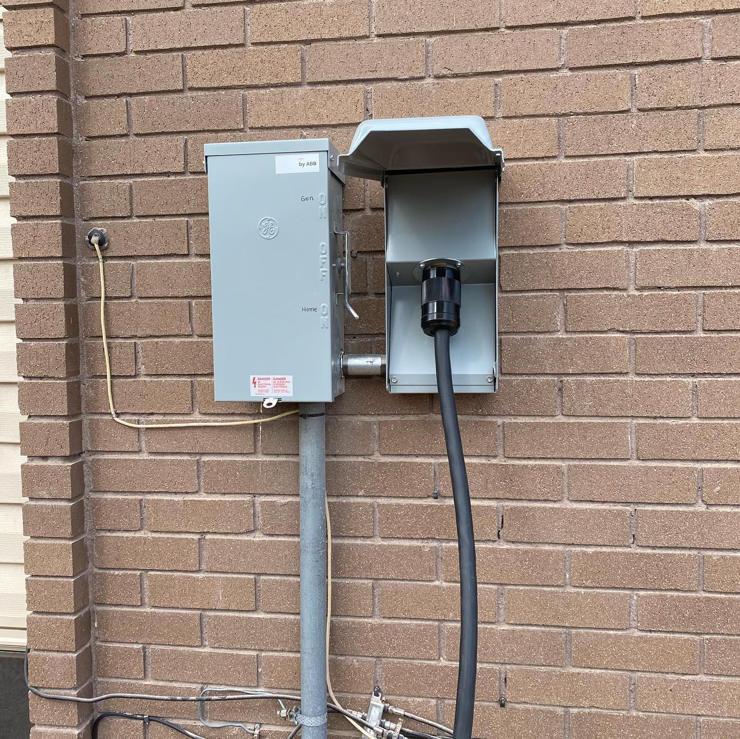 A brick wall with a box and a plug on it