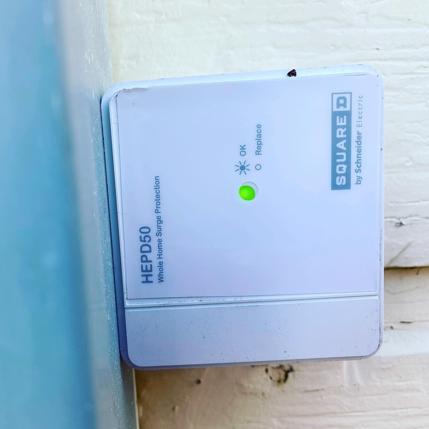 A small white box is sitting on a wooden wall.