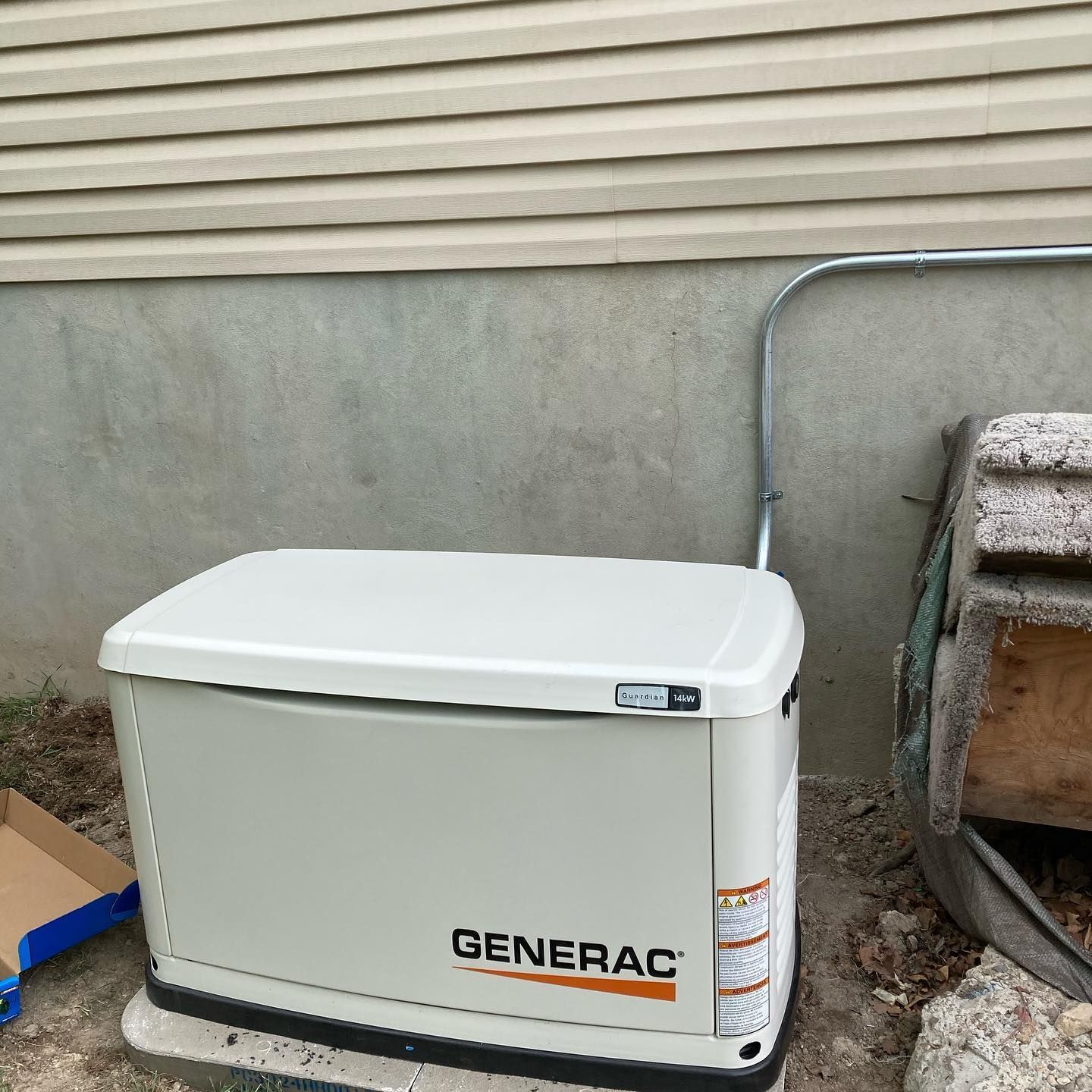 A generac generator is sitting outside of a house.