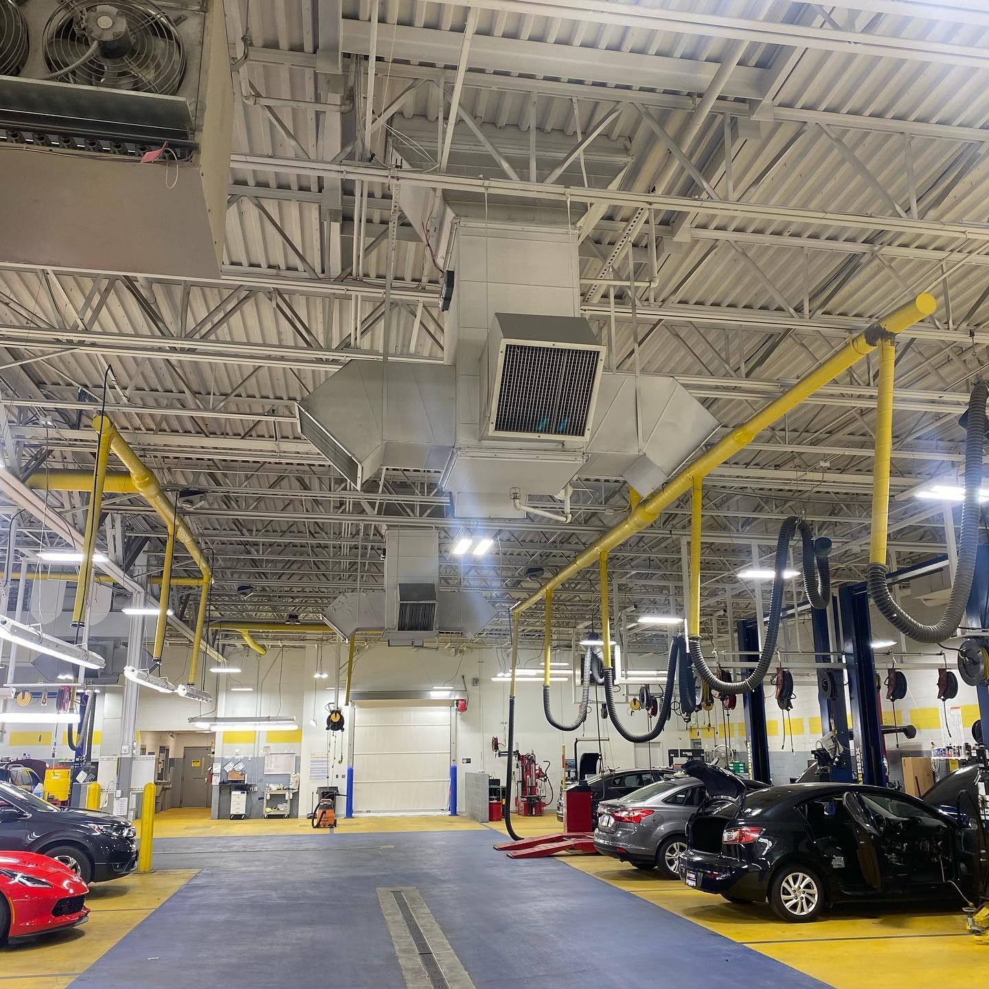 A lot of cars are parked inside of a garage