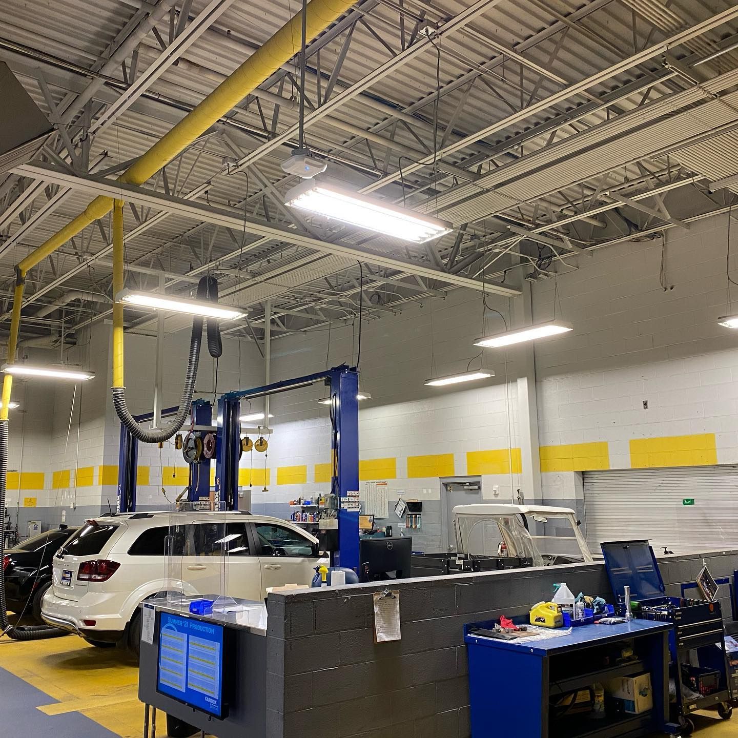 A car is sitting on a lift in a garage.