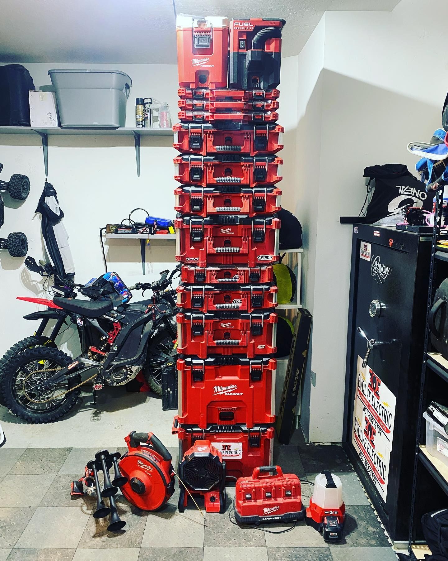 A stack of red tool boxes in a garage with a motorcycle in the background