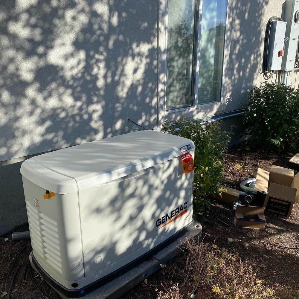 A generator is sitting outside of a house next to a window.