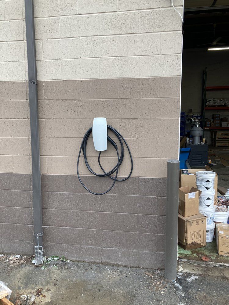A brick wall with a box and a plug on it