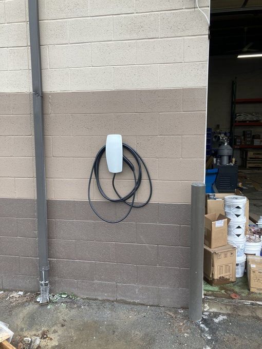 A brick wall with a electrical box attached to it.