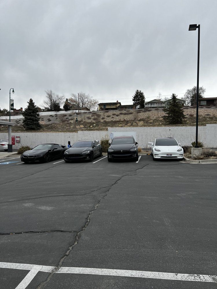 A row of cars are parked in a parking lot.