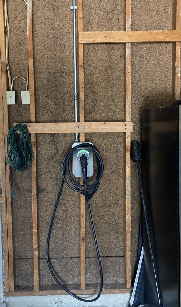 A tesla charging station is attached to the side of a building.