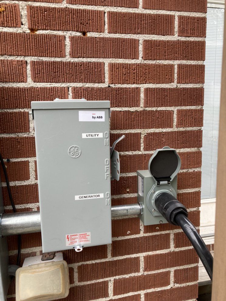 A brick wall with a electrical box attached to it.