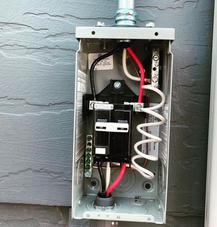 A close up of an electrical box with wires coming out of it