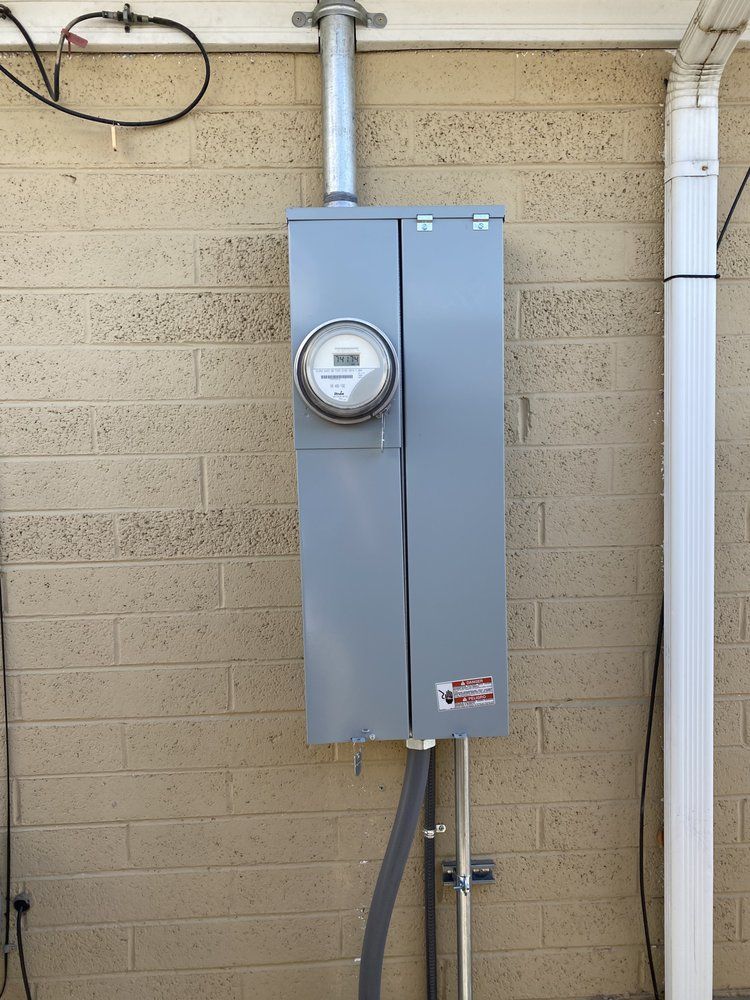 A meter is mounted on the side of a brick wall.