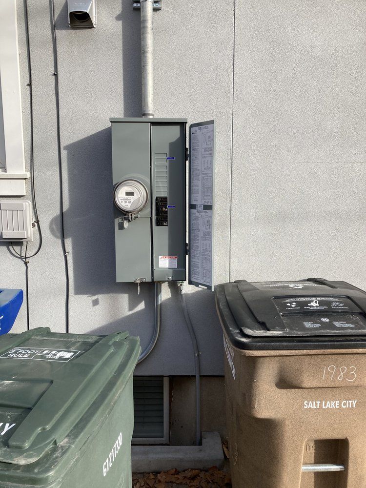 A garbage can is sitting next to a meter on the side of a building.