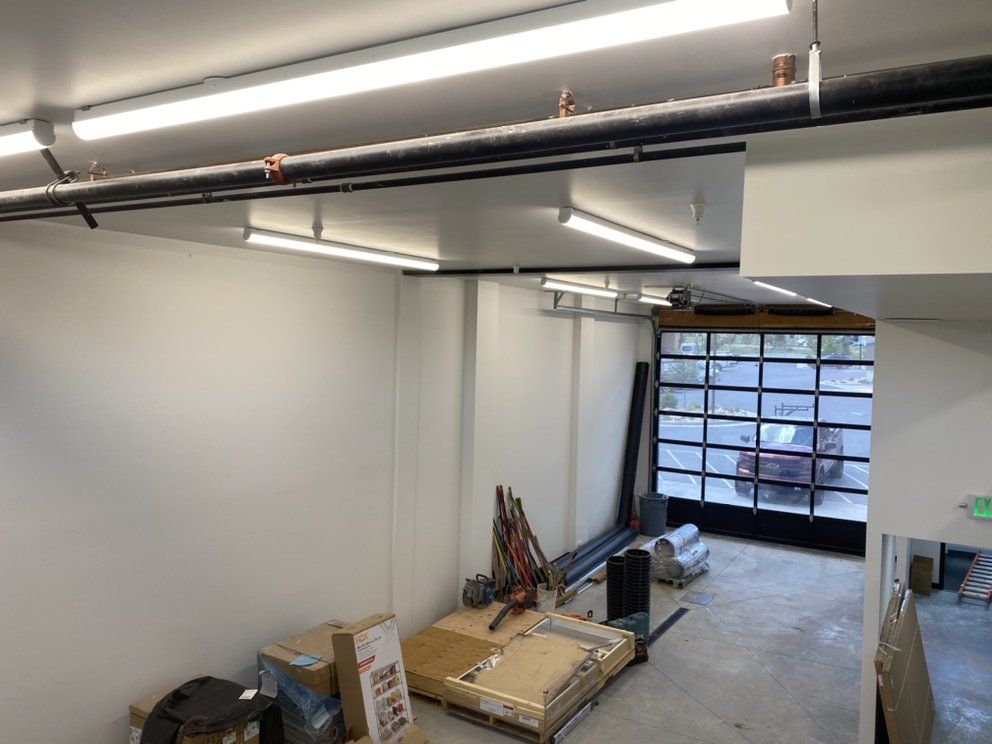 A garage with a glass garage door and a lot of boxes on the floor.