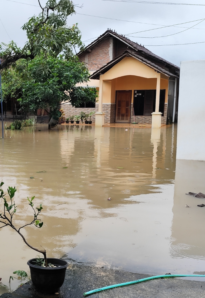Contact Us A house partially submerged in murky brown floodwaters during an overcast day.