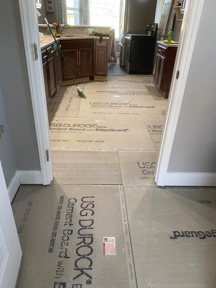 Kitchen floor undergoing renovation, covered in USG Durock cement board sheets.