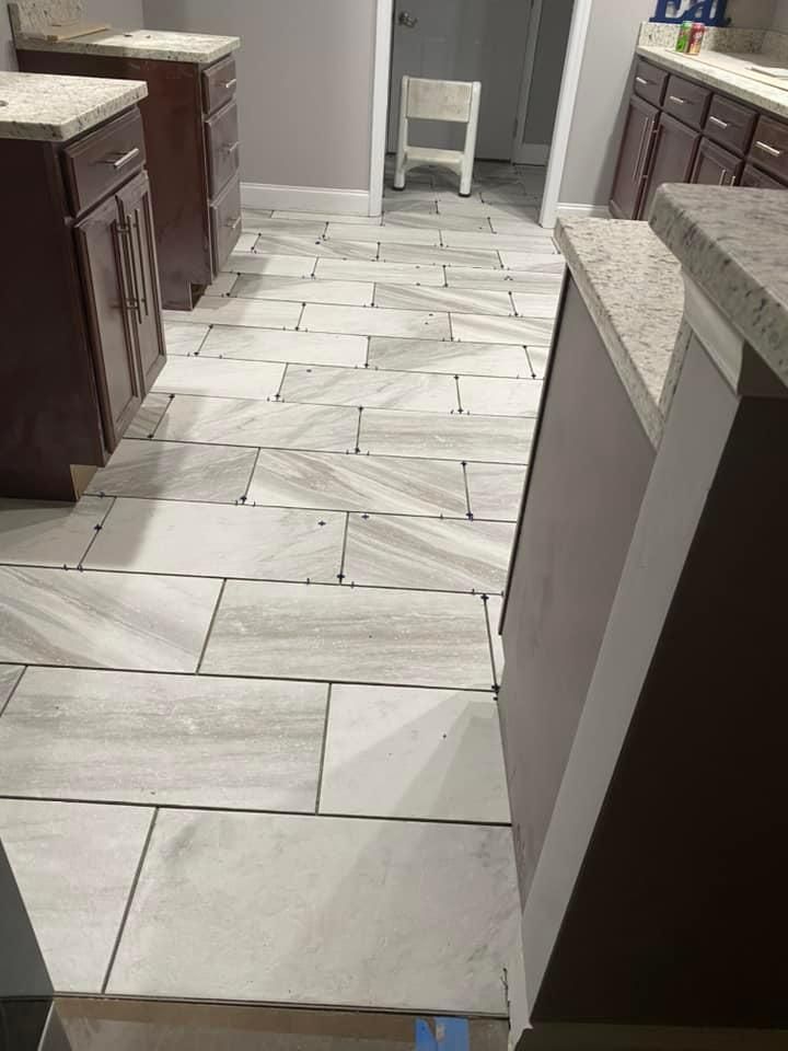 Kitchen with dark cabinets, granite countertops, and light grey rectangular floor tiles.