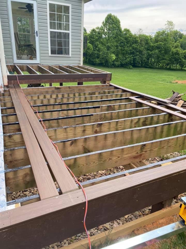 Before pictures of a deck under construction with exposed wooden joists and a partially installed brown composite border.