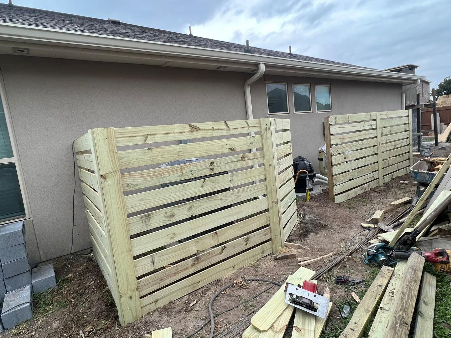 A wooden fence is being built in front of a house.