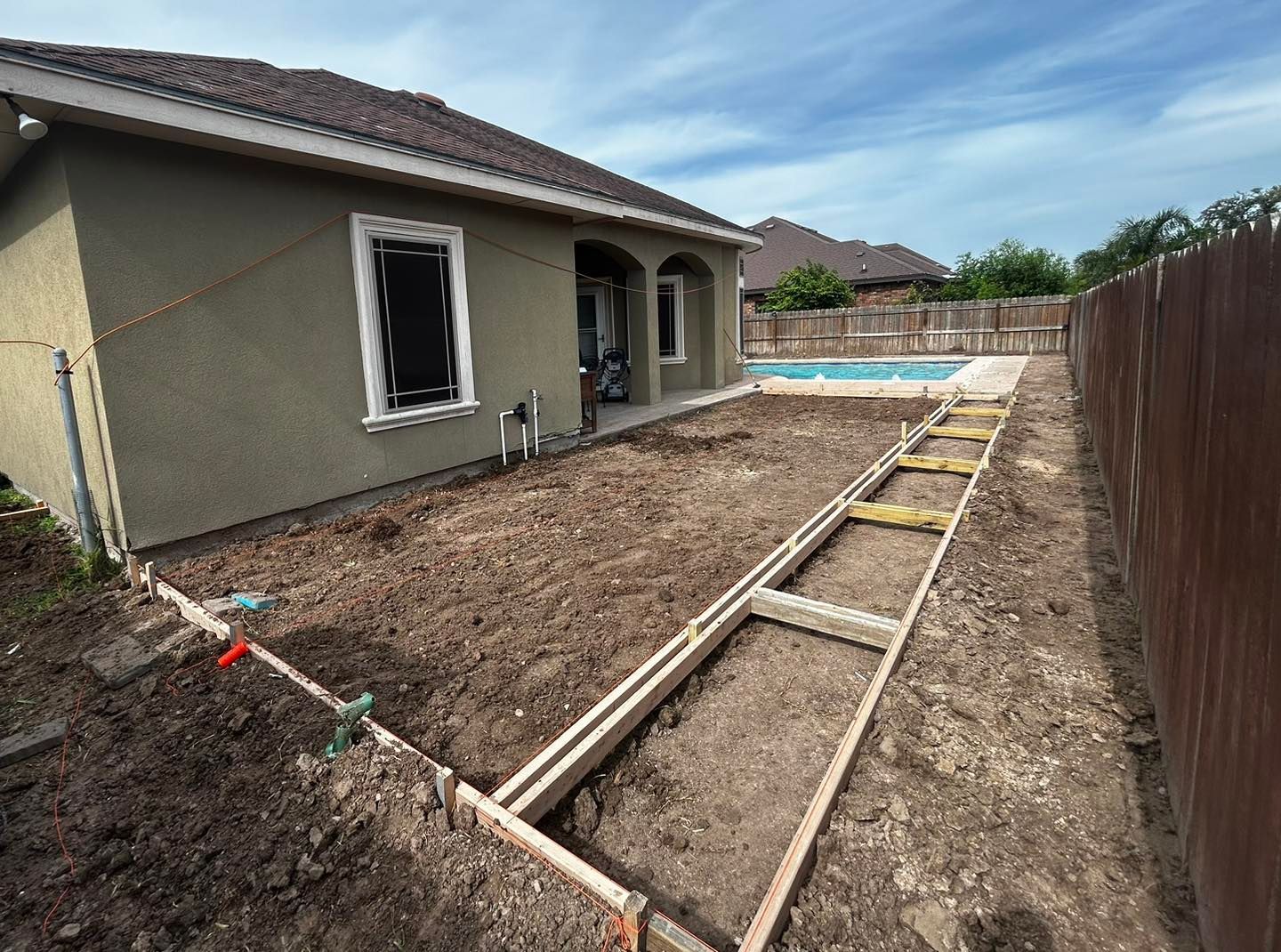 A house is being built next to a pool.