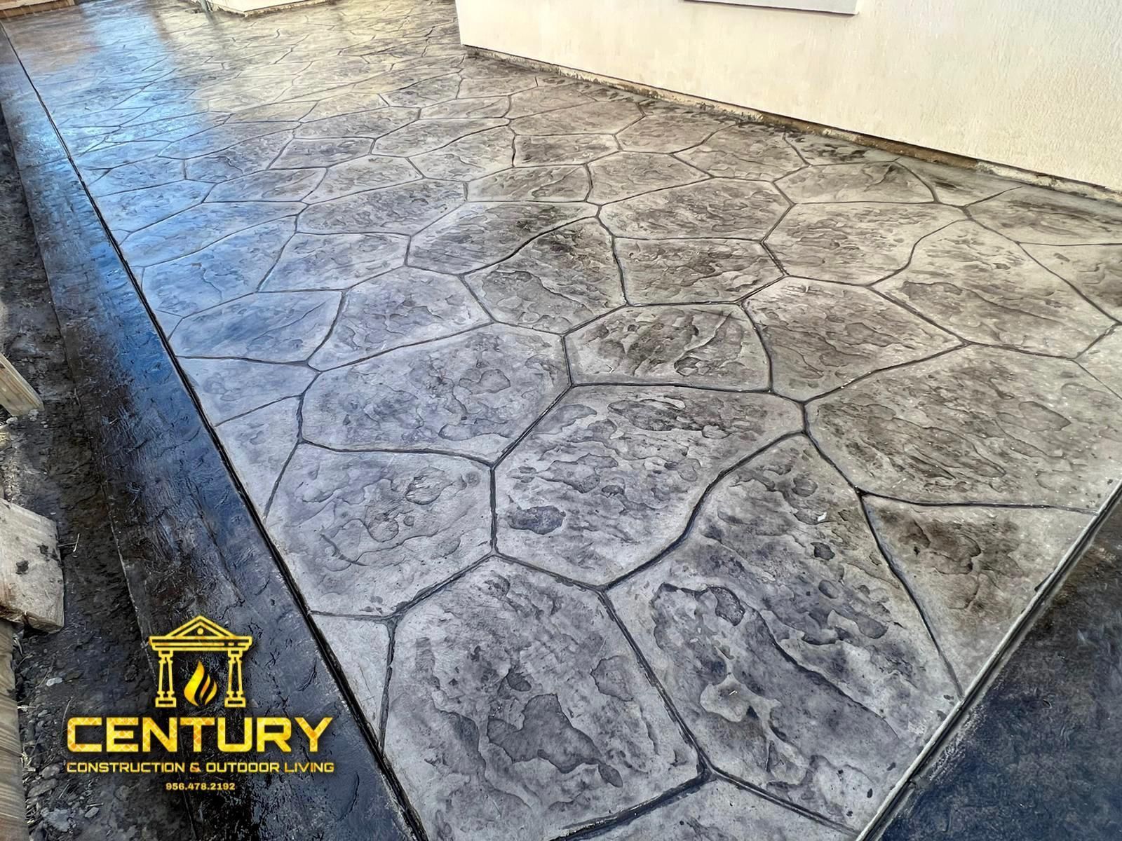 A concrete walkway with a hexagon pattern is being installed in front of a house.