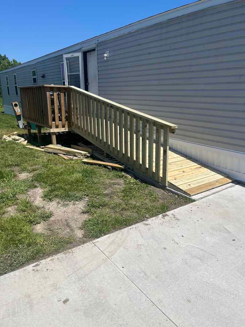 A wooden ramp is being built in front of a mobile home.
