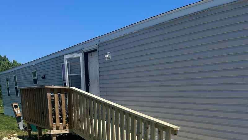 A mobile home with a wooden ramp leading to it.