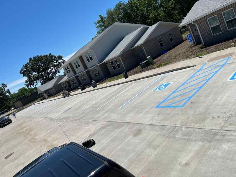 A car is parked in a handicapped parking spot in front of a building