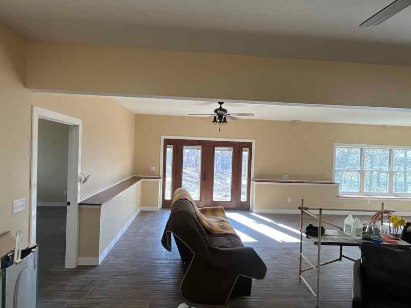 A living room with a couch , chair , table and ceiling fan.
