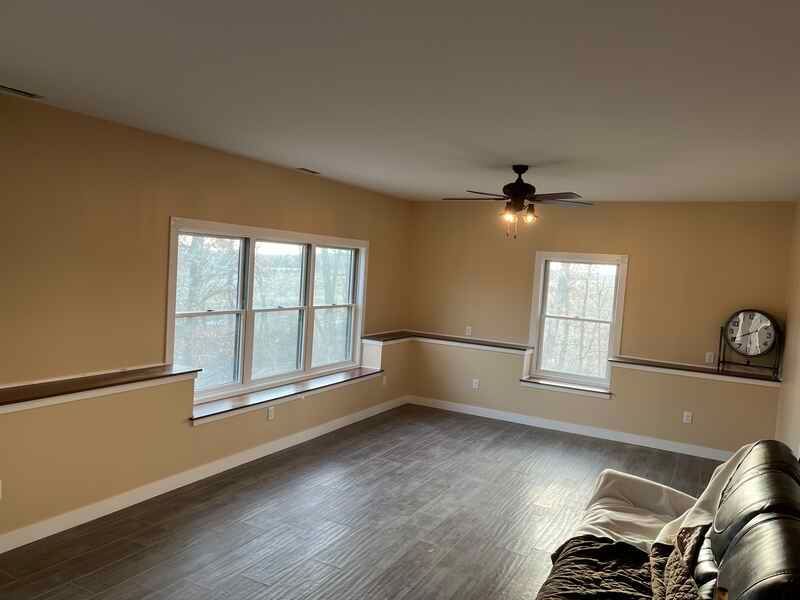 A living room with a couch and a ceiling fan.
