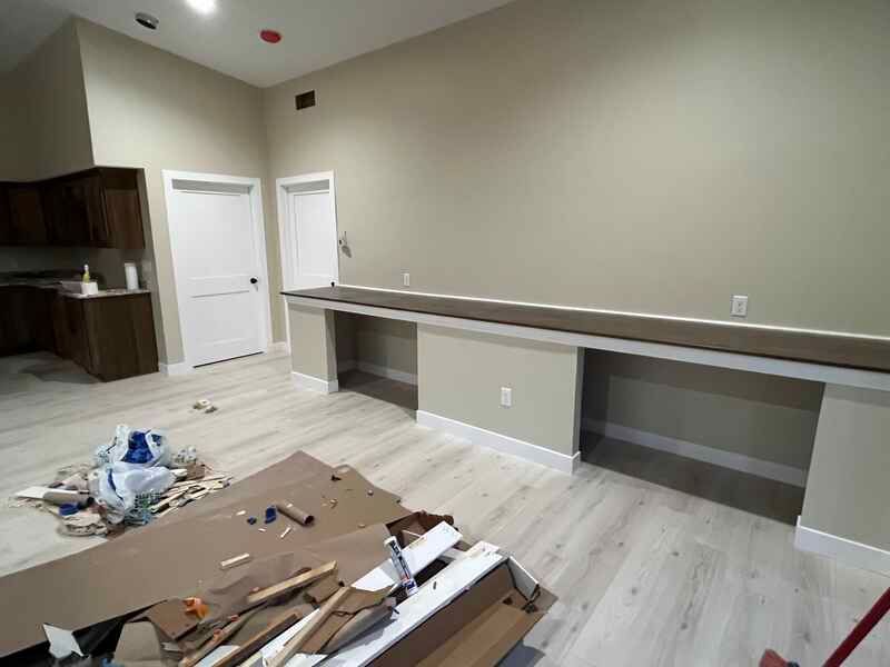 A room with a lot of boxes on the floor and a table in the middle of the room.