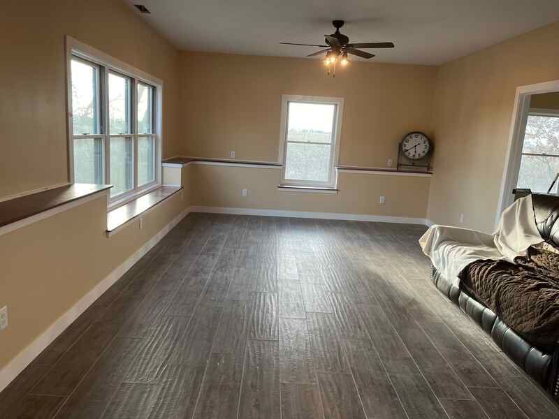 A living room with a couch and a ceiling fan.