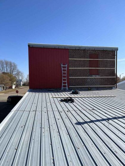 A ladder is sitting on the roof of a building.