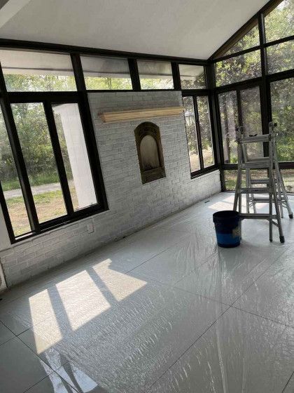 A room with a lot of windows and a ladder in it.