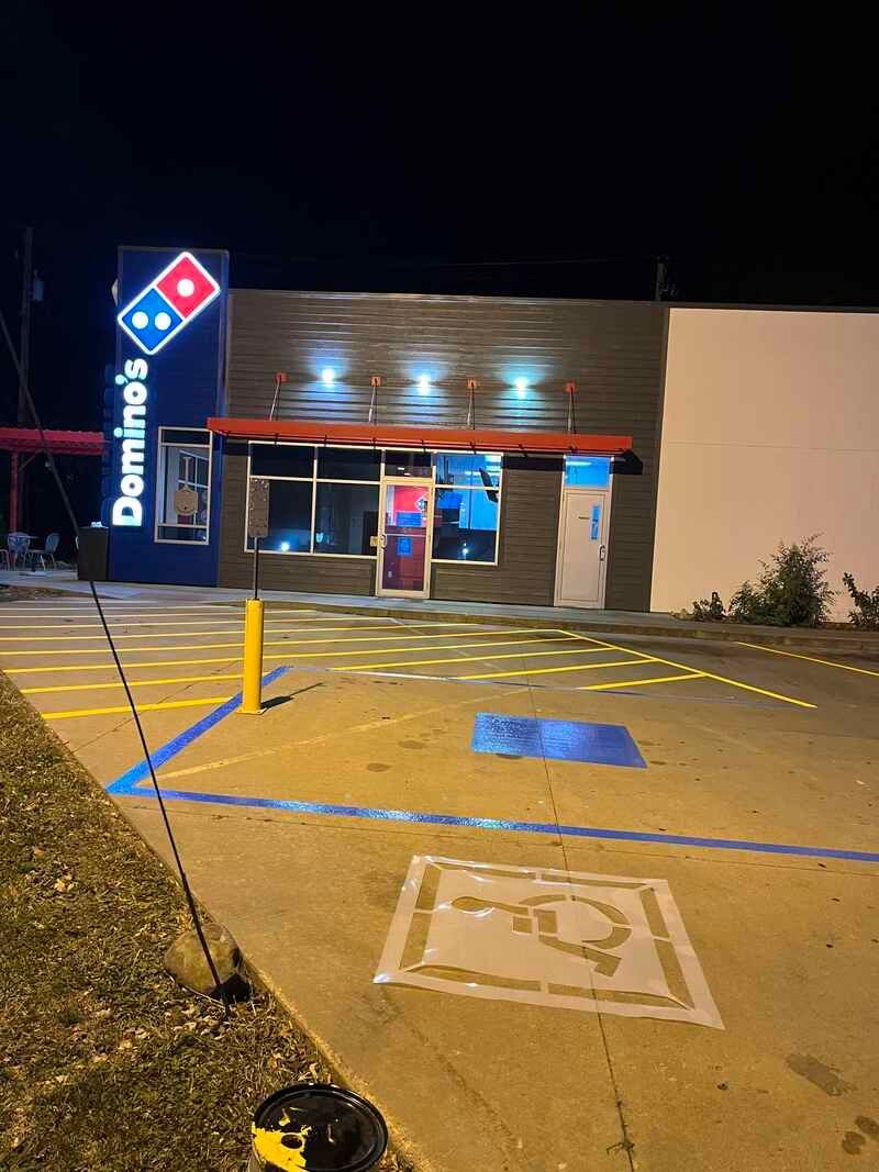 A domino 's pizza restaurant with a handicapped parking spot in front of it.