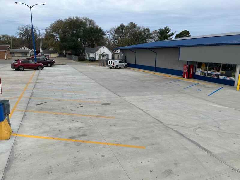 A parking lot with cars parked in front of a building.