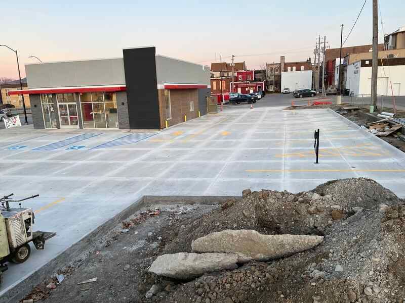 A concrete driveway is being built in front of a building.