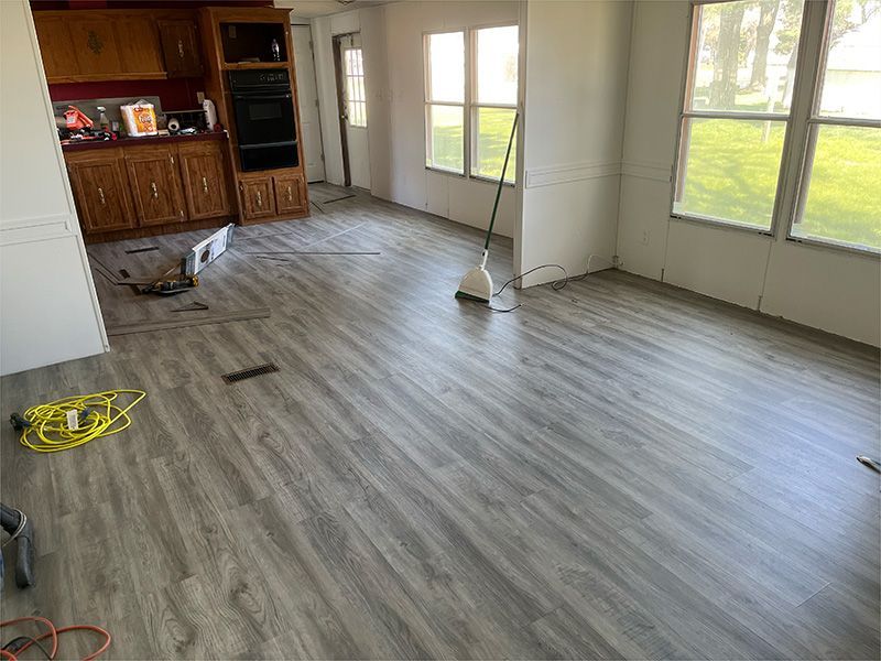 A living room with hardwood floors and a vacuum cleaner.