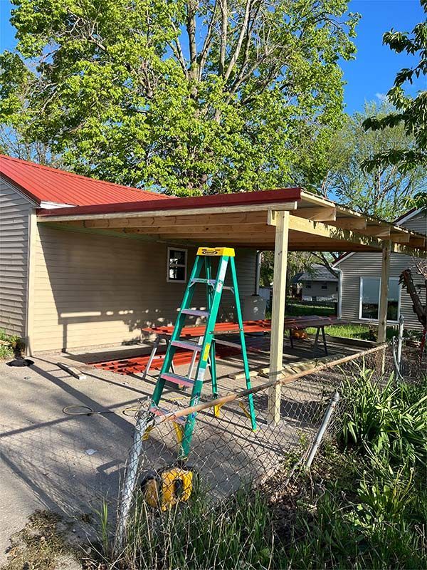 A ladder is sitting in front of a house under construction.