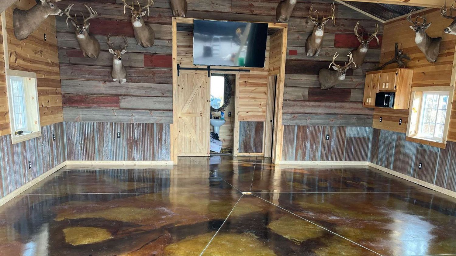 A large room with a concrete floor and a wooden wall.